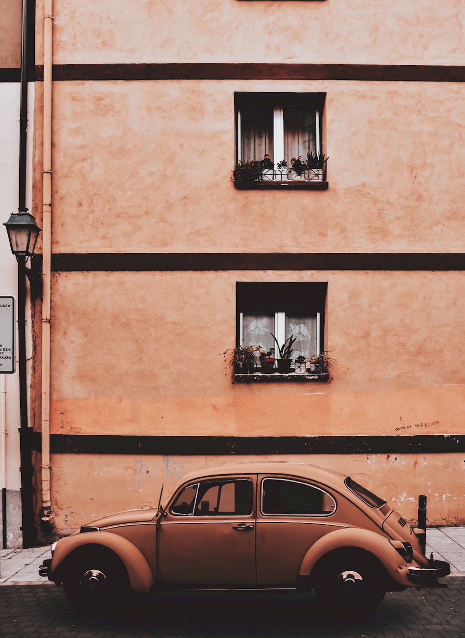 beige volkswagen beetle coupe parked near concrete building