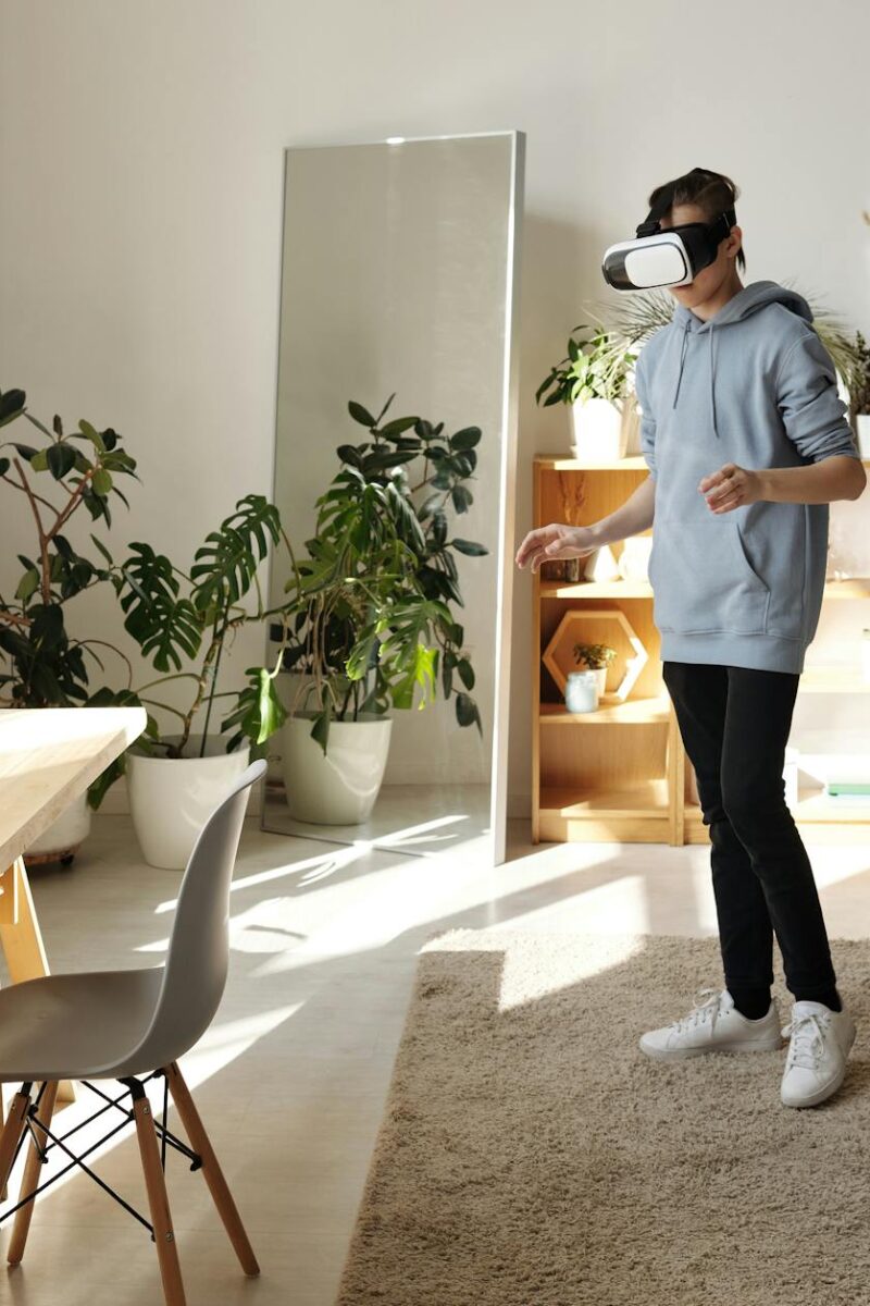 photo of boy standing while using vr headset