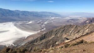 View from Dante’s View in Death Valley showing salt flats, desert floor, and rugged mountains under clear blue sky.