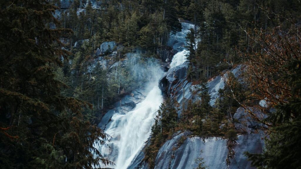 Remote North Carolina waterfall flowing down rugged rocks surrounded by dense green forest