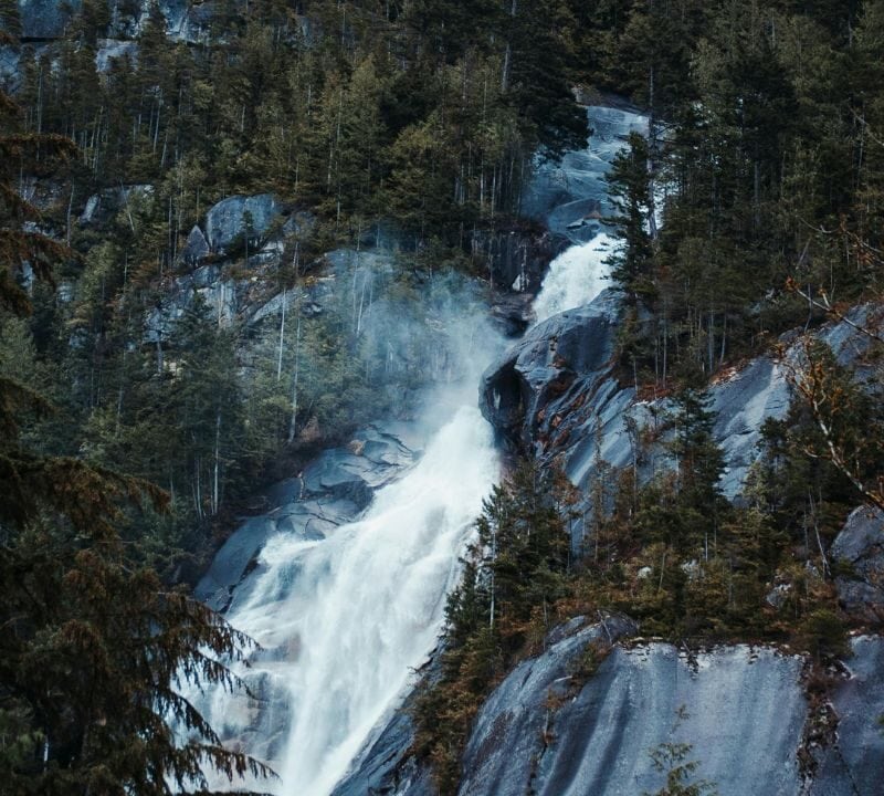 Remote North Carolina waterfall flowing down rugged rocks surrounded by dense green forest