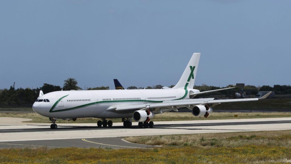 A large commercial aircraft taxiing on a runway under clear skies, representing spontaneous or last-minute air travel options.