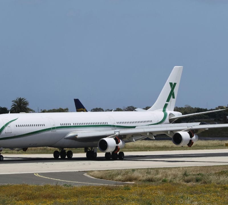 A large commercial aircraft taxiing on a runway under clear skies, representing spontaneous or last-minute air travel options.