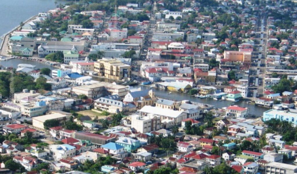 Aerial cityscape of Belize City with canals, colorful roofs, and coastal views.