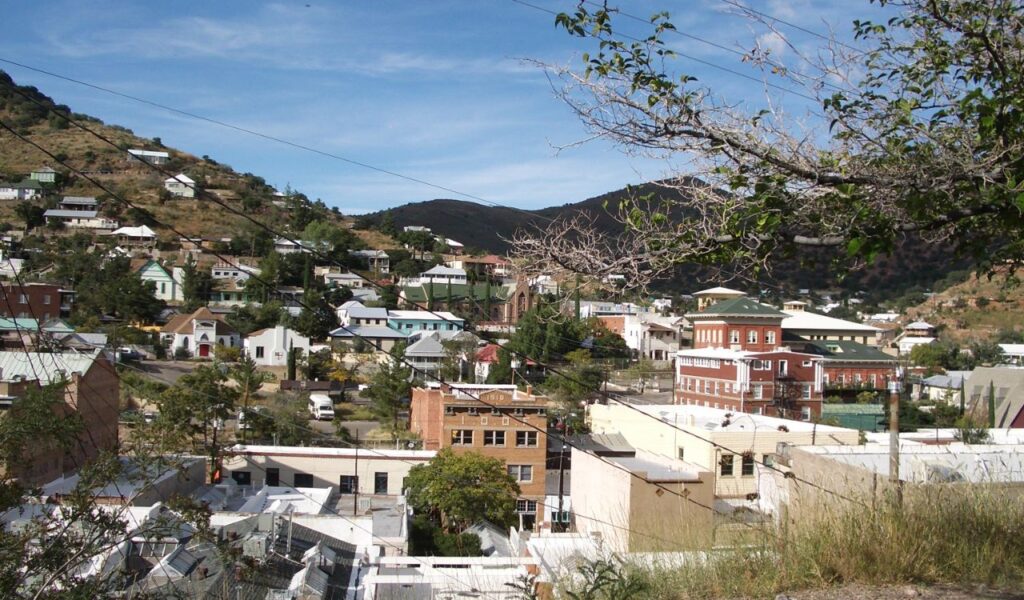 Colorful hillside buildings in historic Bisbee, Arizona under clear blue sky