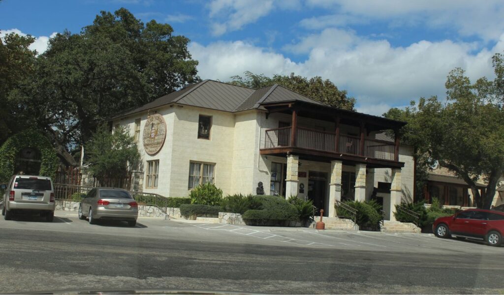 Historic building in Camp Verde, Arizona with parked cars and trees.
