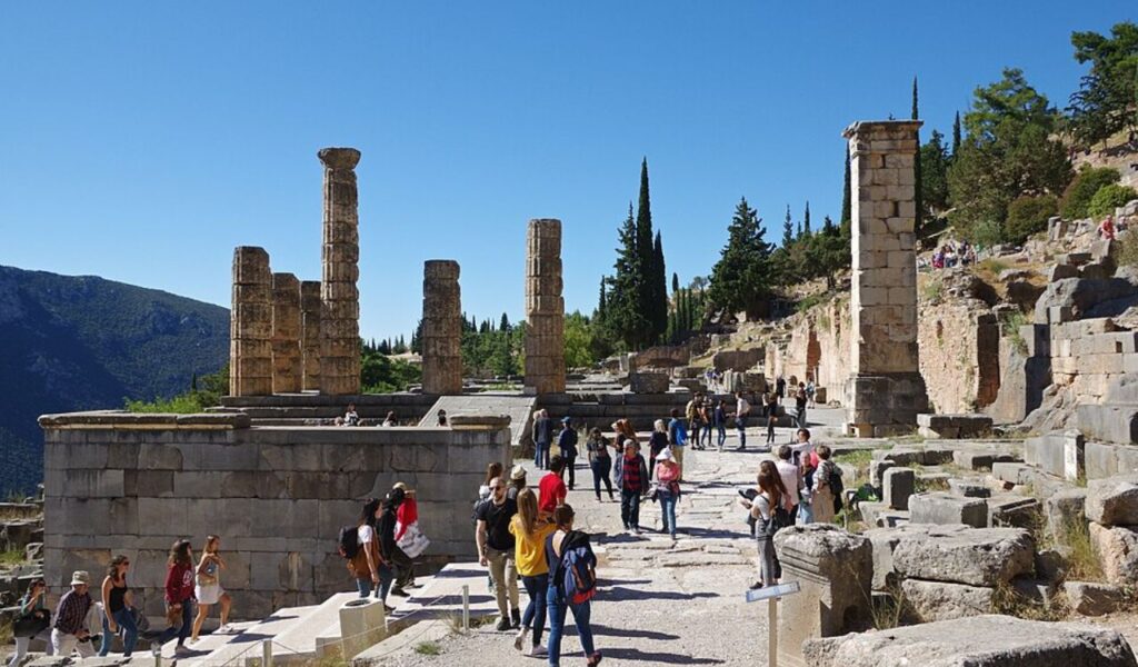 Tourists exploring ancient ruins on a sunny day, representing affordable and culturally rich travel destinations.