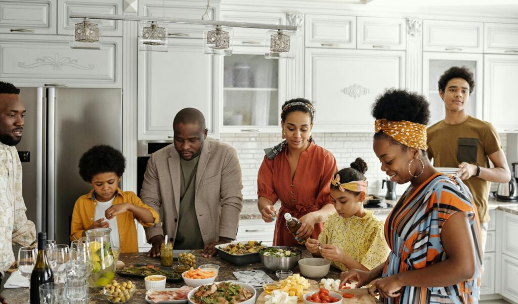 Family preparing and sharing a meal together in a bright kitchen, highlighting the benefits of home-cooked travel meals