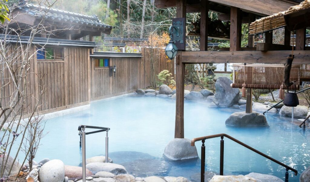 Downata Hot Springs outdoor pool with wooden architecture and rising steam.