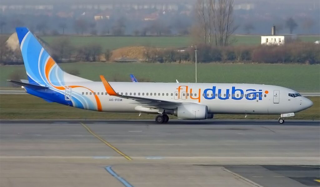 Flydubai aircraft on the taxiway, displaying its vibrant blue and orange swirl tail and bold flydubai branding.