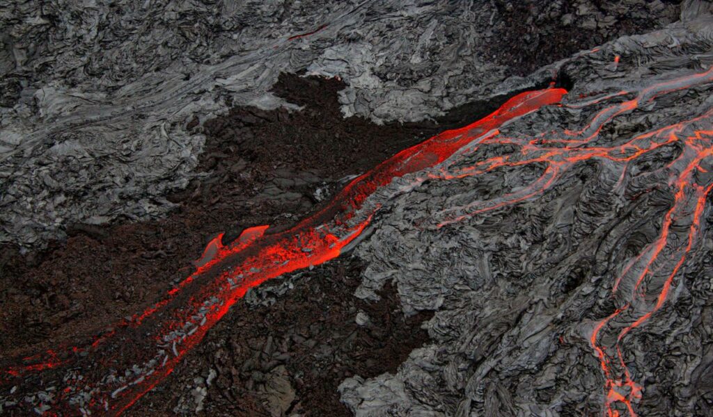 Flowing red-hot lava on volcanic rock at Hawai‘i Volcanoes National Park, Hawaii.
