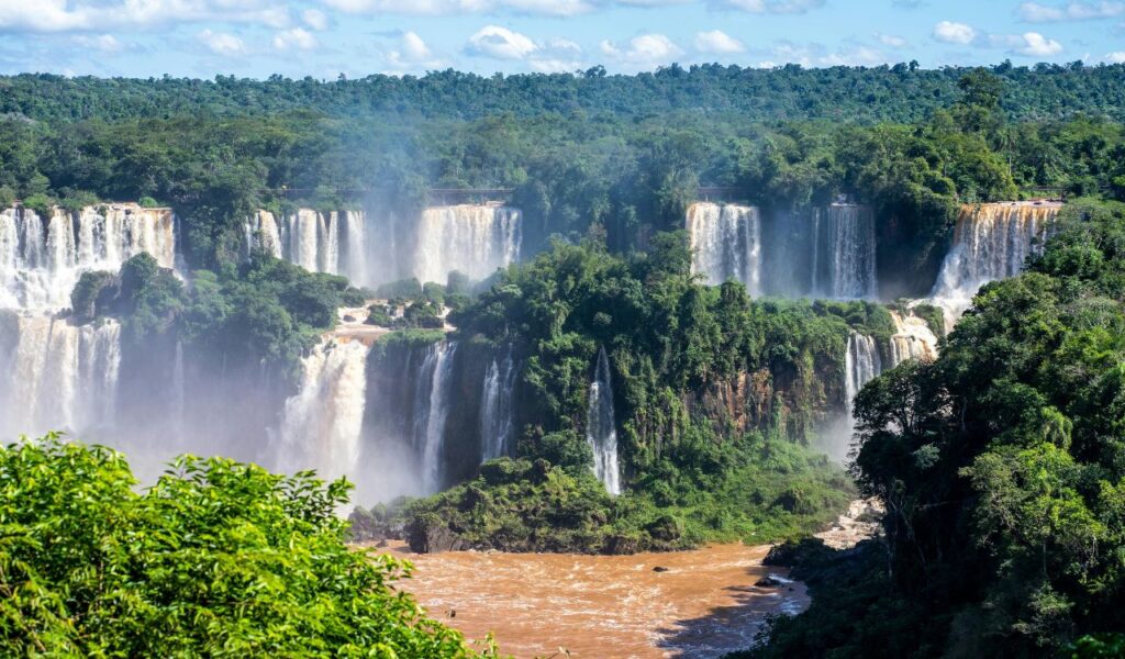 Iguazu Falls in Argentina with multiple cascading waterfalls surrounded by lush green rainforest.