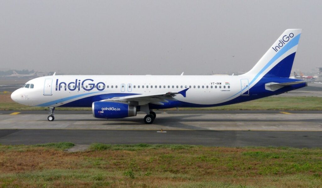 IndiGo aircraft taxis at the airport, featuring a sleek white and blue design with the IndiGo logo on the tail.