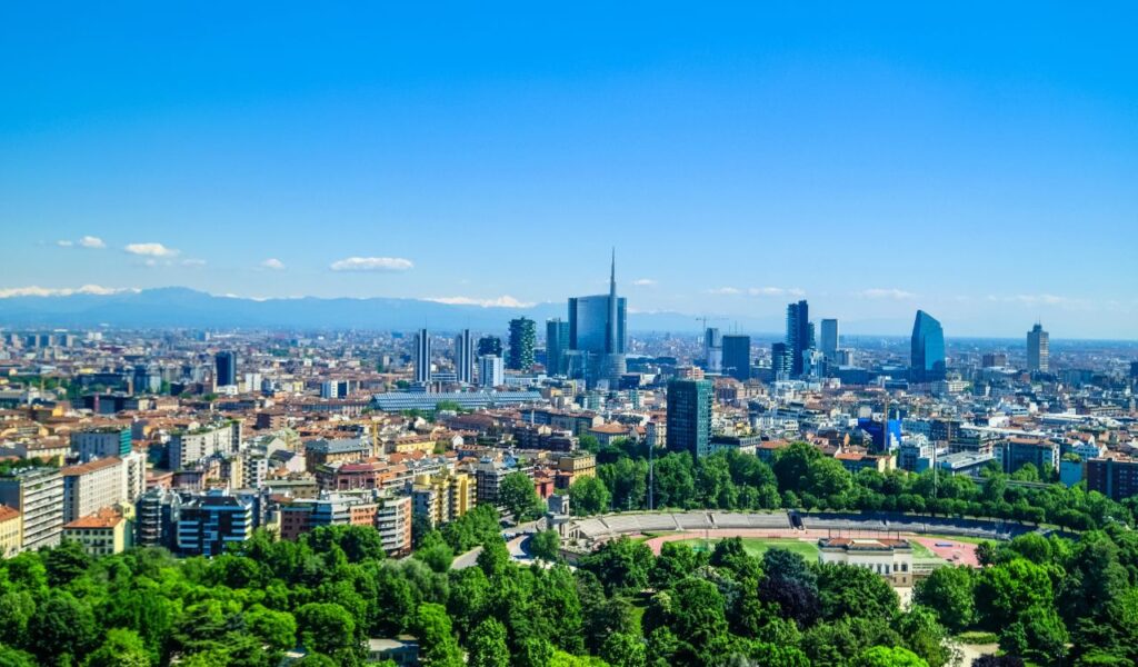 Milan city skyline with modern towers and green parks under clear sky