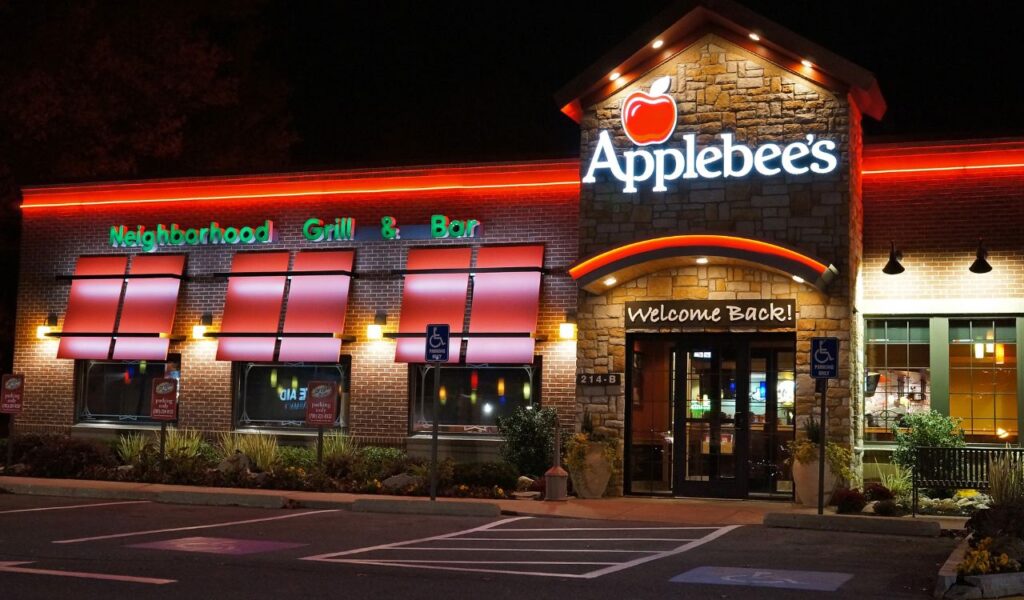 Applebee’s restaurant at night with illuminated signage and 'Welcome Back!' message at the entrance
