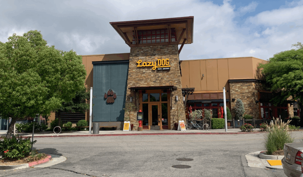 Exterior of Lazy Dog Restaurant and Bar with stone tower entrance and paw print decor