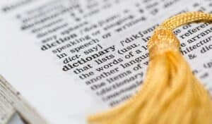 Close-up of a dictionary page highlighting the word “dictionary,” with a yellow tassel bookmark visible on the right.