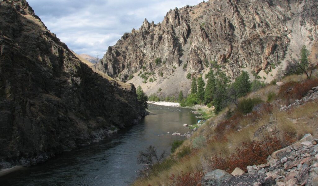 This is a view of the Salmon River in Idaho, surrounded by rugged cliffs and beautiful landscapes, offering a remote and serene environment