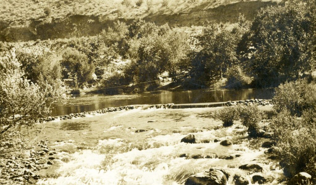 Miracle Hot Springs river with natural dam and flowing water in canyon.