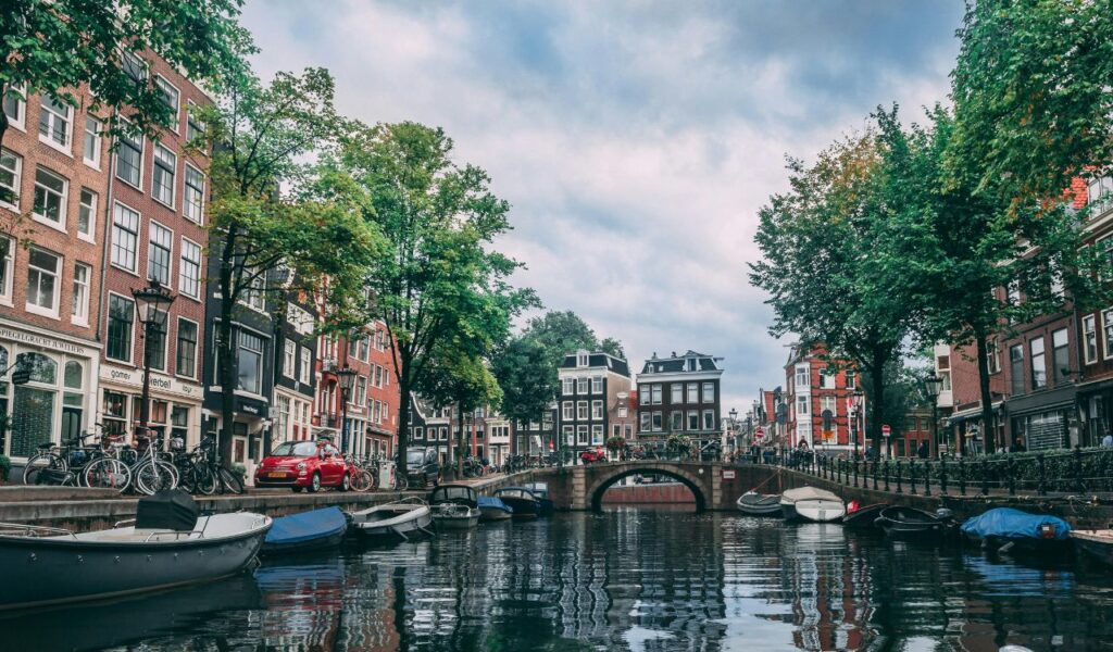Charming canal with boats and historic buildings in Amsterdam, Netherlands.