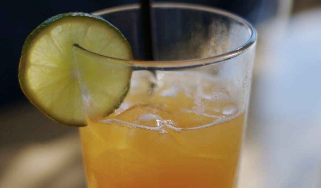 Non-alcoholic mocktail with ice and a lime slice garnish, offering a refreshing and festive beverage