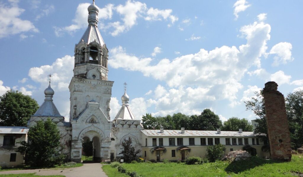 Historic white stone church with silver onion domes in Novgorod, Russia, representing the region’s medieval past.