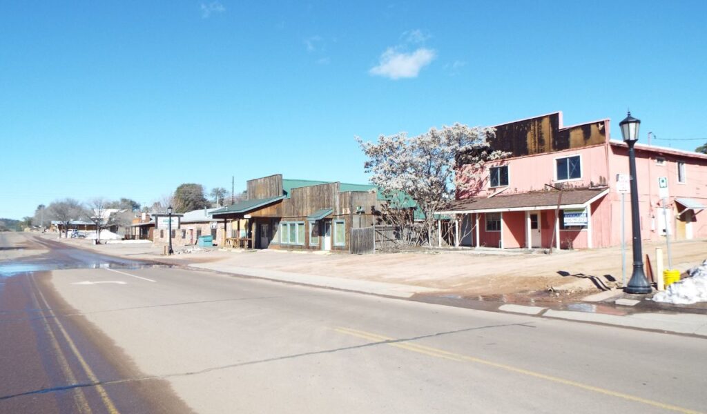 Quiet street in Payson, Arizona with rustic buildings and clear skies.
