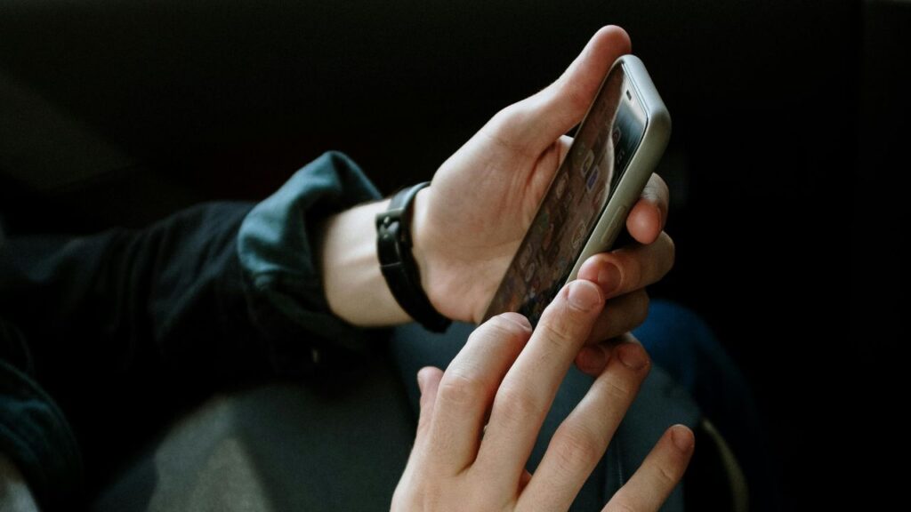 Person in Black Jacket Holding Smartphone