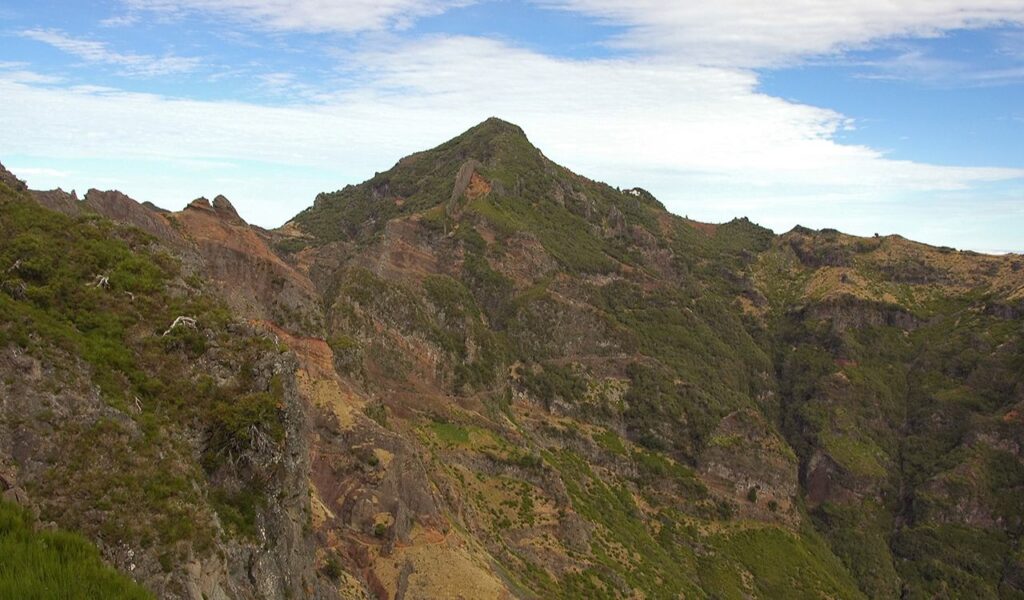 Mountain landscape view of Pico Ruivo, the highest peak in Madeira, Portugal, with rugged green and rocky terrain.