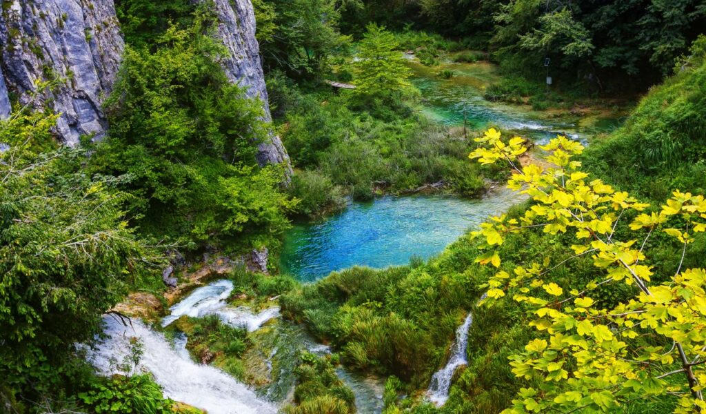 Plitvice Lakes in Croatia with emerald water, waterfalls, and lush green forest.