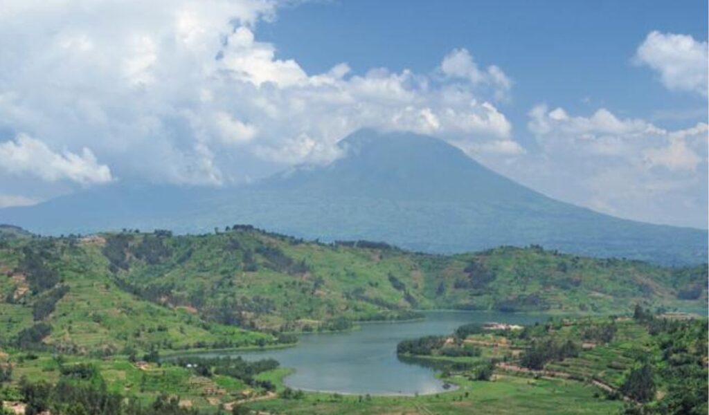 Lake and green hills with Rwanda's Mount Karisimbi in the background