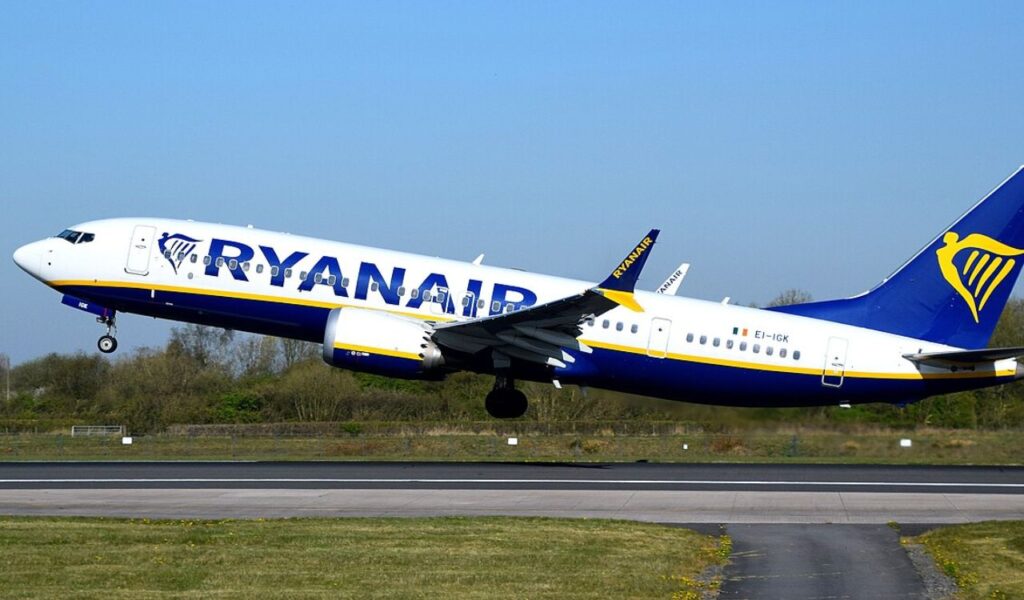 Ryanair jet takes off with its bold blue and yellow livery, highlighting the iconic harp logo on the tail.