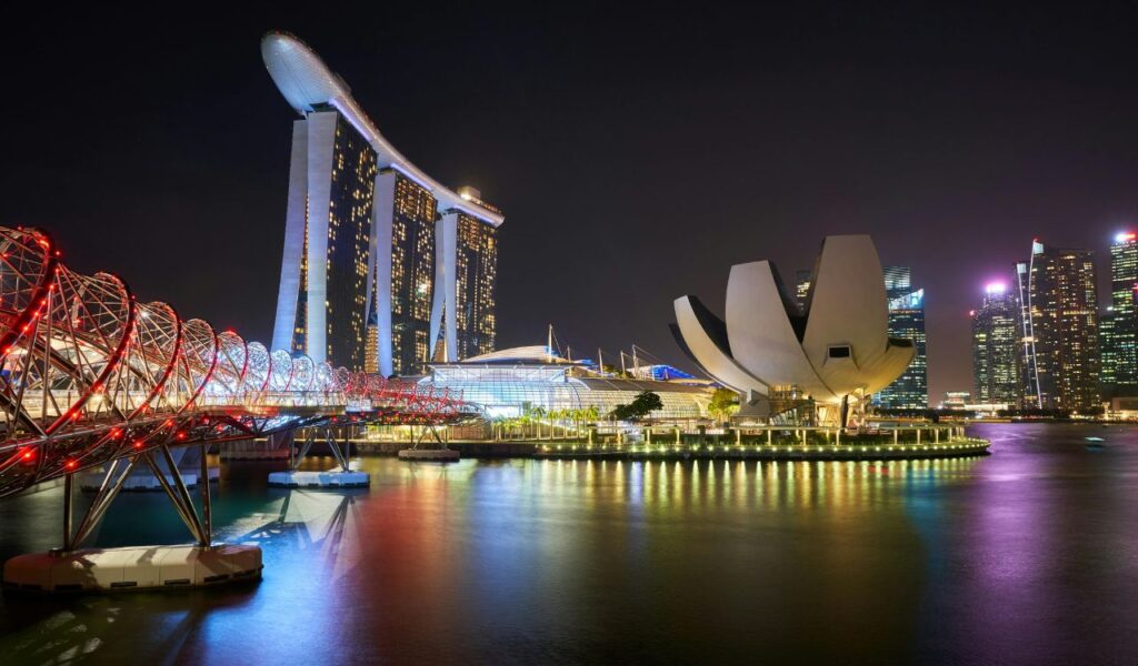 Singapore Marina Bay at night with Helix Bridge and Marina Bay Sands skyline.