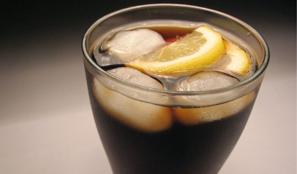 Sugary soft drink with ice and lemon slices, showing a refreshing yet sugary beverage option