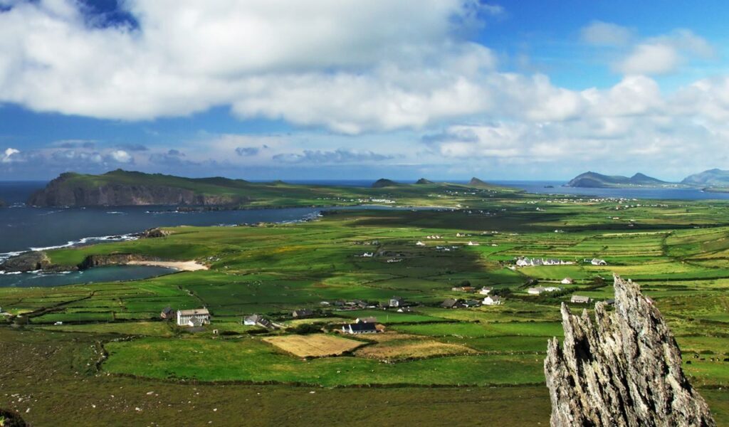 Sweeping view of County Kerry, Ireland, with green fields, scattered cottages, and ocean cliffs near The Old Church House.