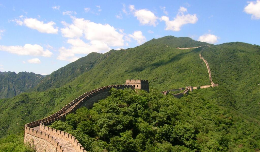 The Great Wall of China snaking through green hills near Mutianyu, close to the eco-friendly Schoolhouse retreat in Beijing.