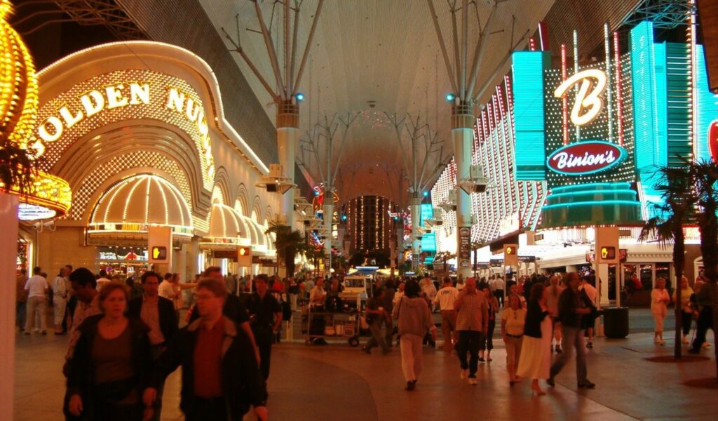 Crowds walking under the lit-up Fremont Street canopy in downtown Las Vegas, showcasing vibrant off-strip nightlife.