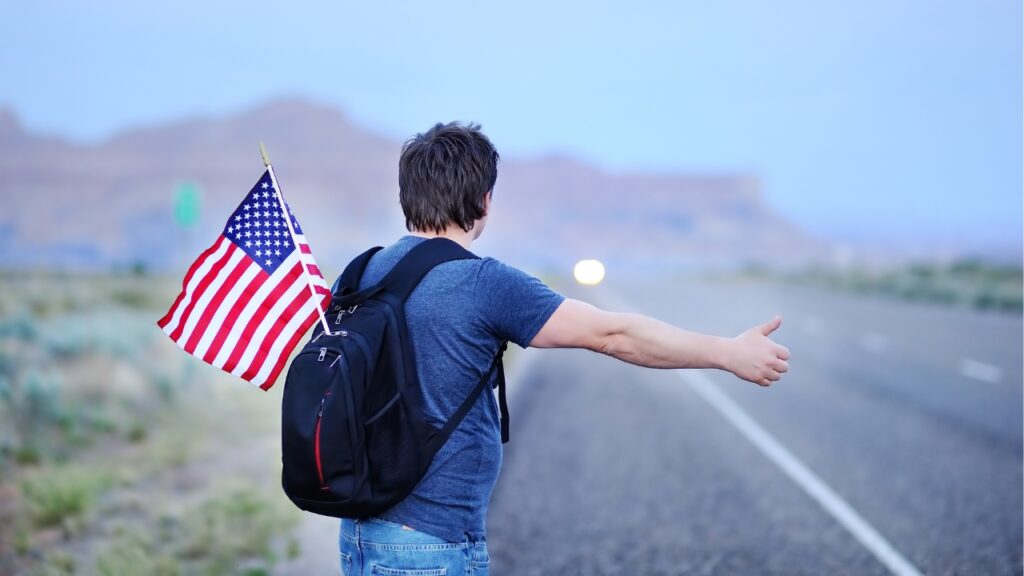 male tourist with american flag in backpack