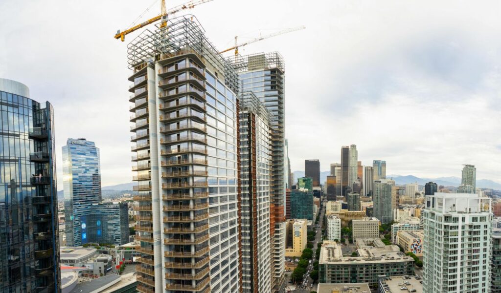 Modern cityscape of Montevideo, Uruguay, showcasing high-rise buildings under construction, cranes, and a mix of contemporary and older architecture.