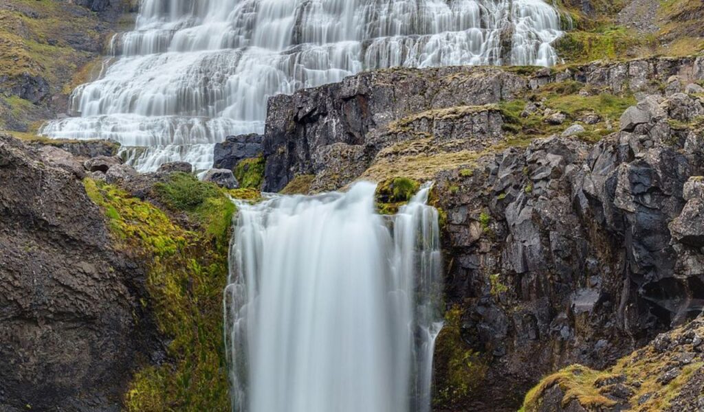 Bearwallow Falls cascading over rocky cliffs in lush forest setting.