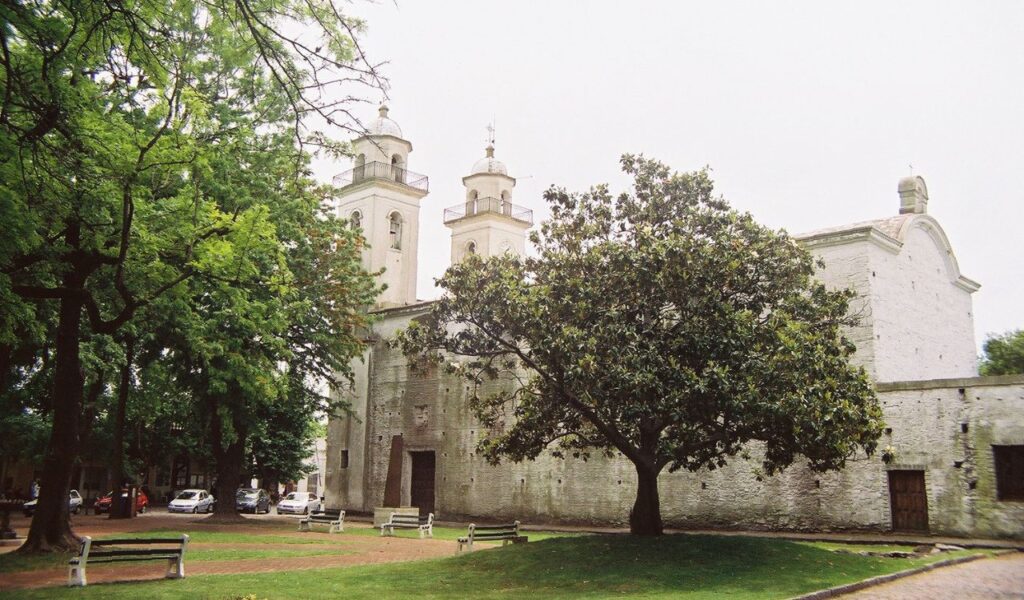 Historic stone church surrounded by trees in Colonia del Sacramento, Uruguay.