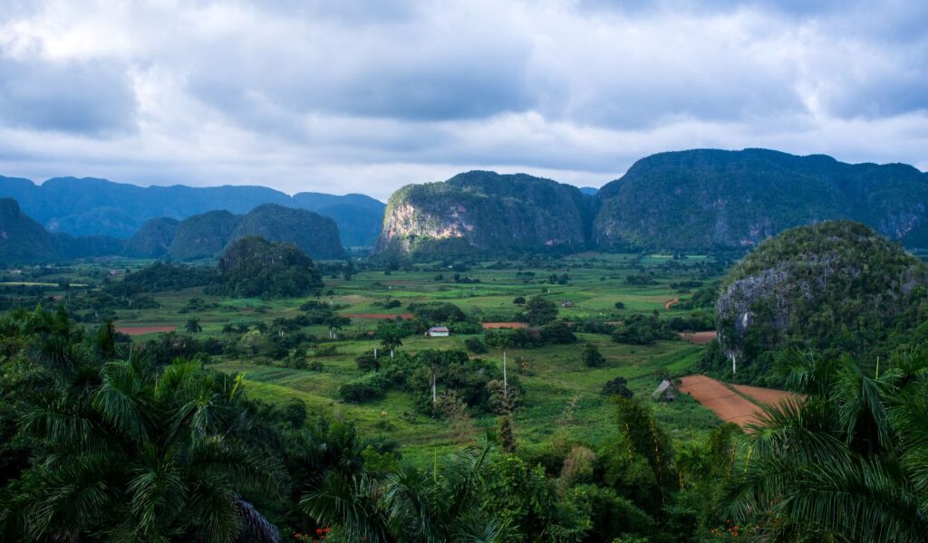 Viñales Valley’s lush green fields, limestone hills, and cloudy sky in rural western Cuba.