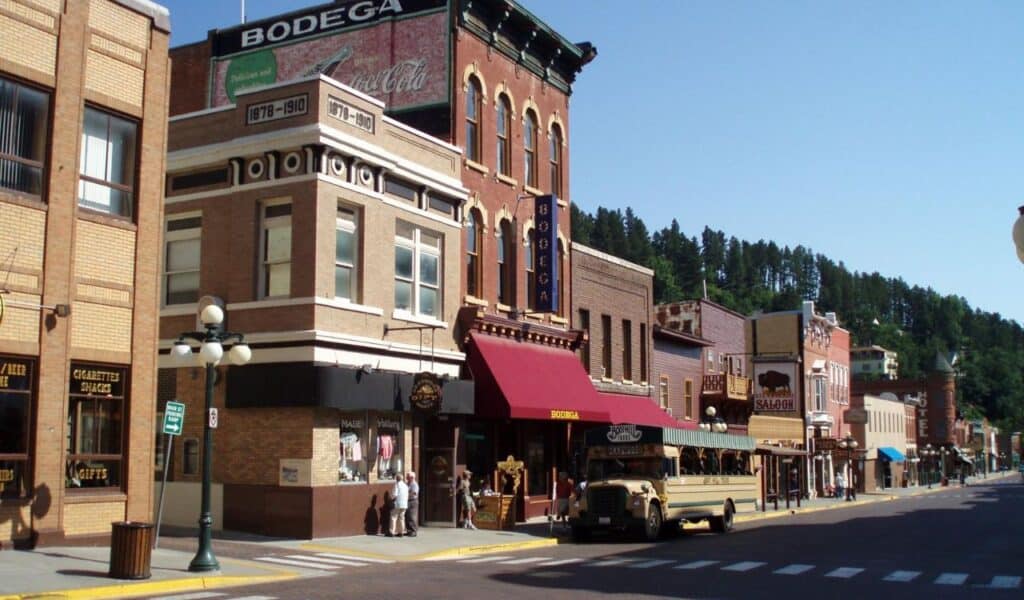 Historic Deadwood, South Dakota, with vintage buildings, saloons, and an old tour bus.