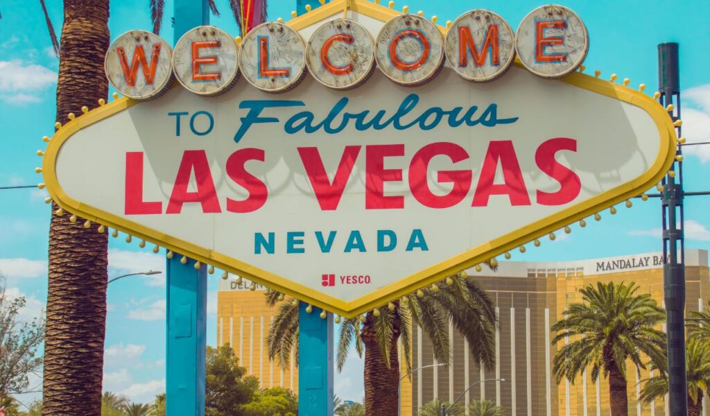 The image shows the iconic "Welcome to Fabulous Las Vegas" sign, located in Nevada, with a vibrant background.