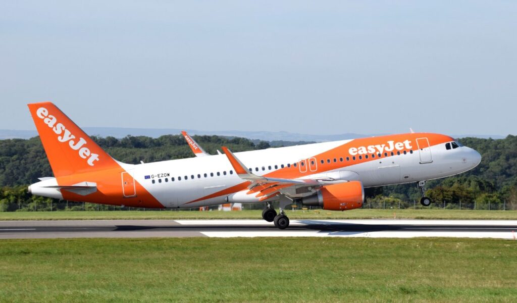 easyJet aircraft lifts off the runway, sporting its signature orange and white low-cost carrier branding.