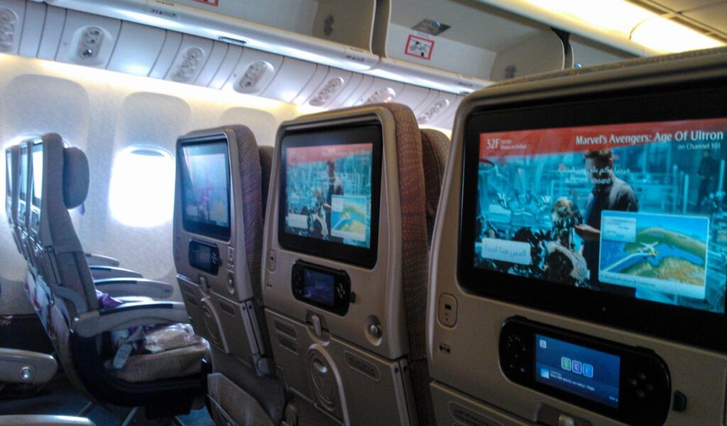 Economy cabin with personal screens, perfect for keeping kids entertained during long international flights.