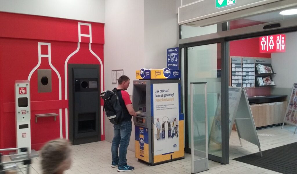 Traveler using an ATM in a foreign country, hinting at potential foreign transaction charges or unexpected ATM fees.