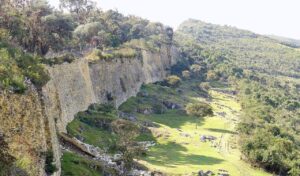 Massive ancient stone walls of Kuelap fortress surrounded by forested hills in Peru.