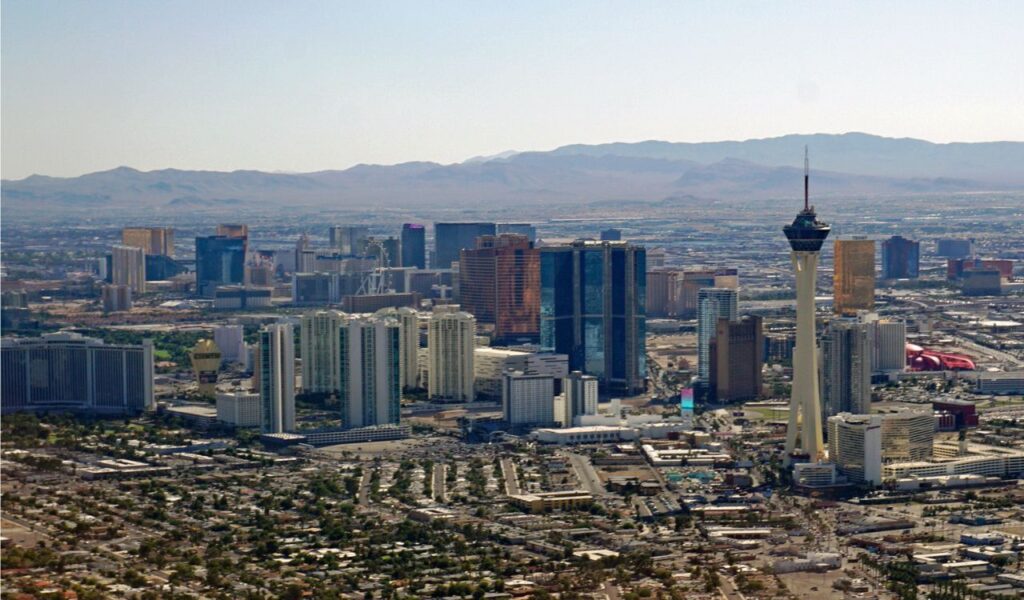 Aerial view of Las Vegas skyline with the Stratosphere Tower and surrounding cityscape in daylight.