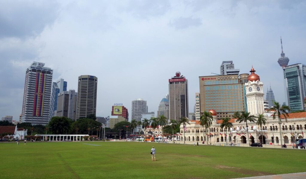 Skyline view of Kuala Lumpur with Sultan Abdul Samad Building and solo traveler on Merdeka Square